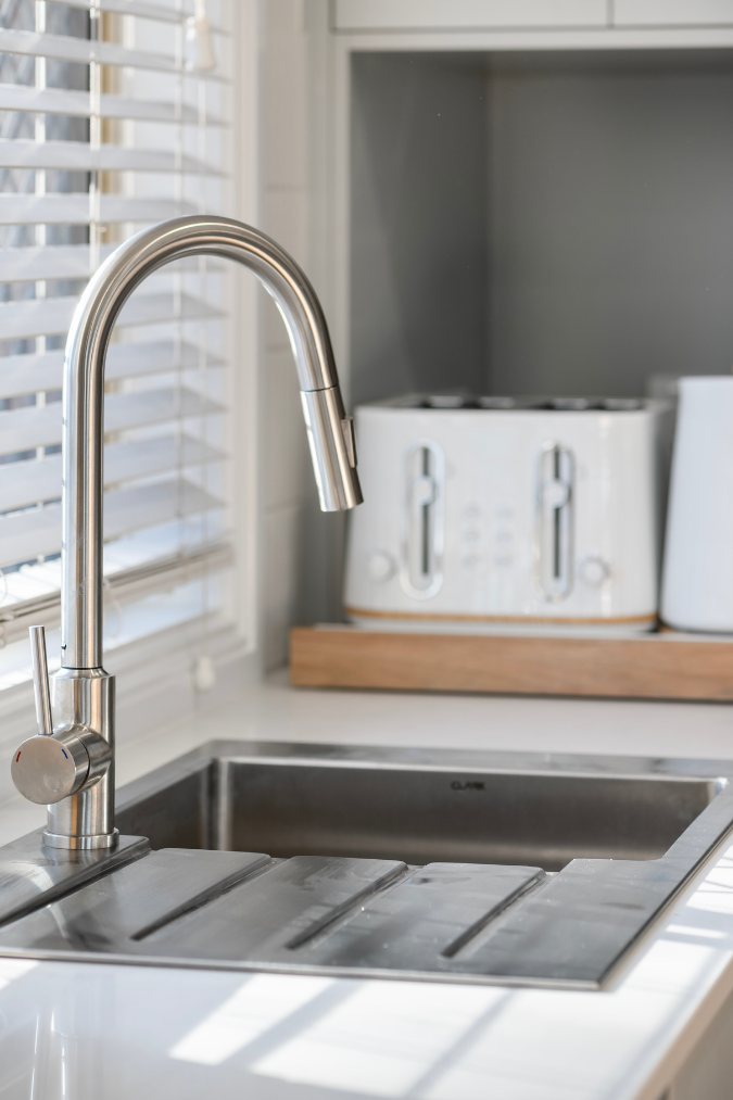 Sink detail with a chrome pull-down tap and integrated drainer grooves — 8 Bishop