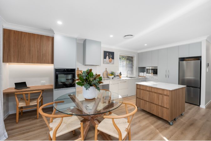 Grey kitchen with a built-in desk nook, round dining table with wishbone chairs and timber island — 8 Bishop