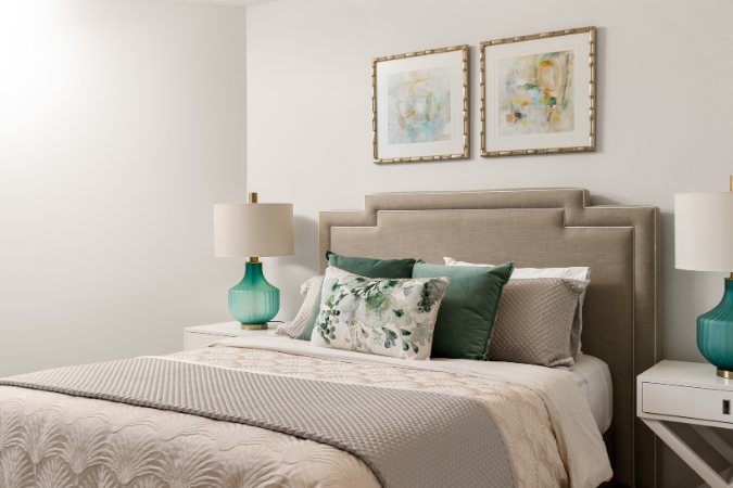 Bedroom with a tufted headboard, teal glass lamps and framed abstract artwork — Kangaroo Point Villa 8